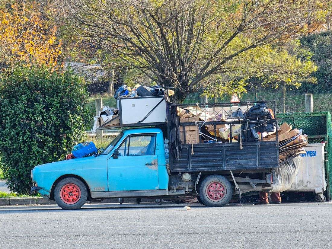 A loaded pickup truck hauling away old furniture and scrap